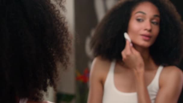 Spiegelreflexion weibliche Waschgesicht mit Schwamm micellar Wasser Tonikum Gesichtspflege Schönheit Routine Afroamerikanerin Mädchen mit Wattepad Wischen Gesicht entfernen Make-up Hautpflege Akne-Verfahren - Filmmaterial, Video