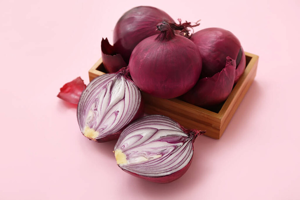 Wooden box with fresh red onions on pink background - Photo, Image
