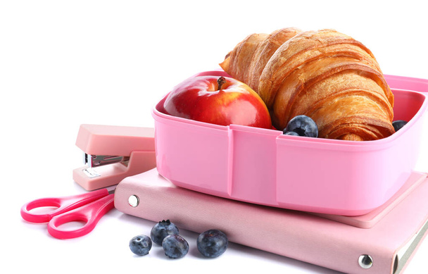 Канцелярские принадлежности и обеденная коробка с вкусной едой изолированы на белом фоне - Фото, изображение