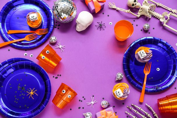 Frame made from Halloween party table setting on purple background - Photo, Image