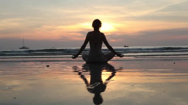 vrouw praktizerende yoga op het strand - Video