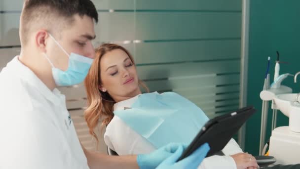 患者は相談中に口腔の状態について明確な情報を得る. 歯科医は,歯の診断と治療に対する専門的なアプローチを示しています - 映像、動画