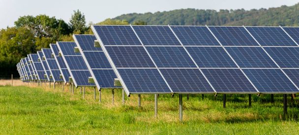 Local de produção de energia solar no campo, durante o verão na Inglaterra rural, fornecendo energia limpa e sustentável para áreas e aldeias locais, na área de Gloucester. - Foto, Imagem