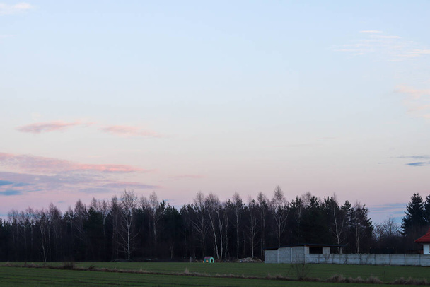 beautiful sunset over a field with a large white house and a small village - Photo, Image