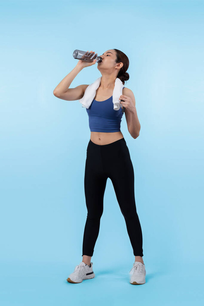 Sportovní a sportovní asijské ženy odpočívající a pít vodu po intenzivním tréninku kardio cvičení. Zdravé cvičení a fit péče o tělo životní styl pronásledování ve studiu natočil izolované pozadí. Silný - Fotografie, Obrázek