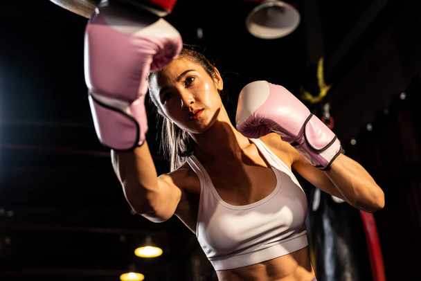 Aasian naaras Muay Thai nyrkkeilijä lyömällä kovaa nyrkkeily koulutus istunto, tuottaa lakko hänen sparraus kouluttaja yllään nyrkkeilyhanskat, esittelee Muay Thai nyrkkeily tekniikka ja taito. Virikkeitä - Valokuva, kuva