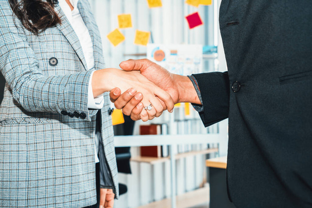Az üzletemberek kezet ráznak a vállalati irodában, ami szakmai megállapodást mutat egy pénzügyi szerződéssel kapcsolatban. Jivy! - Fotó, kép