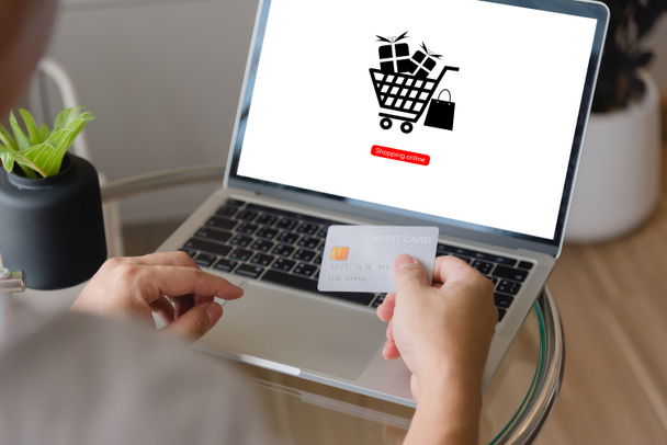 Рука тримає кредитну картку за допомогою ноутбука з онлайн-додатком для покупок. концепція маркетингу електронної комерції та платіжного інтернет-банкінгу. - Фото, зображення