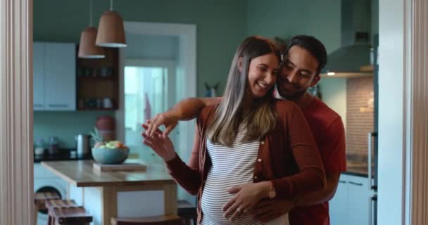 Pregnant, dancing and couple in a kitchen with love to celebrate pregnancy together with happiness in a home. Night, care and happy new parents with unborn baby or child in a house for quality time. - Séquence, vidéo