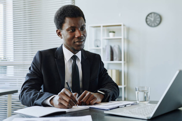 Портрет успішного чорного бізнесмена, який пише в планувальнику під час управління фінансами для компанії, копіювати простір - Фото, зображення