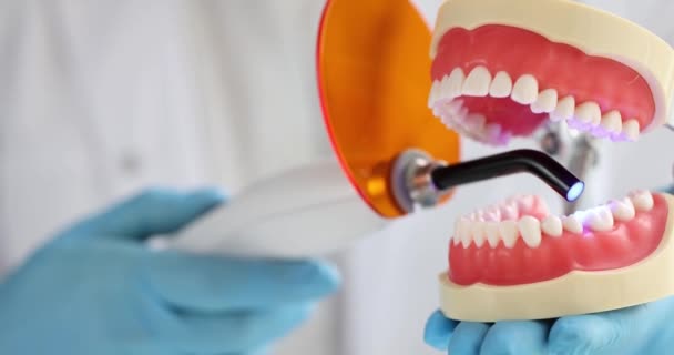 Dişçi fotopolimer lamba ve parlak mavi lamba. Diş hekimi diş protezlerini tedavi eder. Dolgu malzemelerini sakız kabını yerleştirir. - Video, Çekim