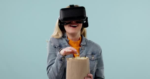 Realidad virtual, mujer y palomitas de maíz, vídeo divertido con experiencia 3D, metáfora y tecnología de futuro sobre fondo azul. Snack de maíz, película de comedia y software, espacio de maqueta y mundo digital en el estudio. - Imágenes, Vídeo