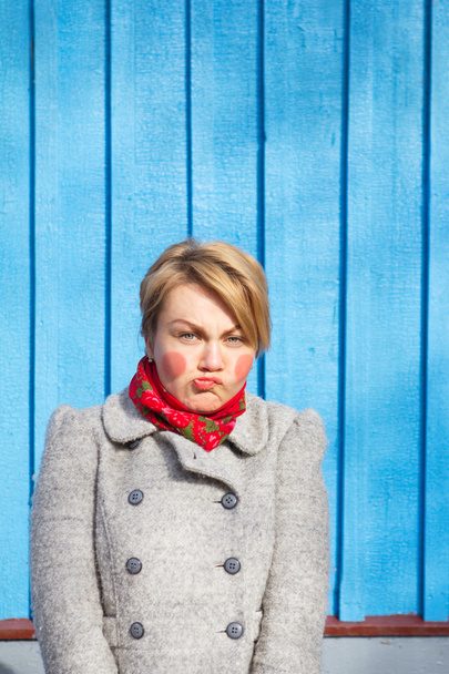 Porträt einer lustigen Frau auf blauer Holzwand, gesättigte Farbe - Foto, Bild