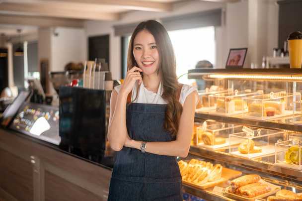 Een Aziatische vrouw ondernemer of barista werken in moderne coffeeshop, concept klein bedrijf  - Foto, afbeelding