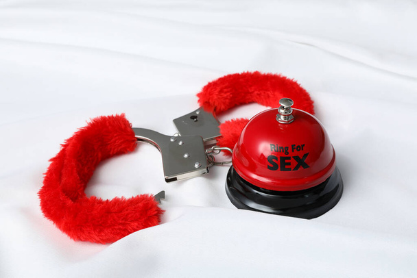 Červené, načechrané pouta pro sex hrát na bílém pozadí. - Fotografie, Obrázek