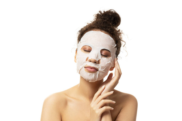 PNG, jolie fille dans un masque cosmétique sur sa facette, isolée sur fond blanc - Photo, image