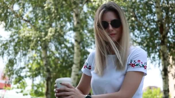 γυναίκα σε casual ρούχα με ένα φλιτζάνι καφέ για να πάει έξω - Πλάνα, βίντεο