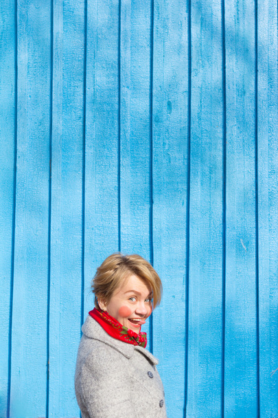 portrét ženy vtipné na modré dřevěné zdi, syté barvy - Fotografie, Obrázek