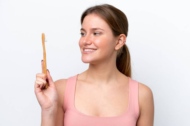Young caucasian woman isolated on white background with a toothbrush - Φωτογραφία, εικόνα