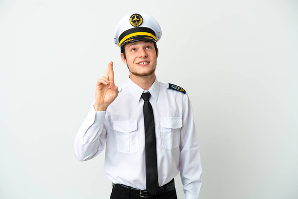 Airplane pilot isolated on white background with fingers crossing and wishing the best - Photo, Image