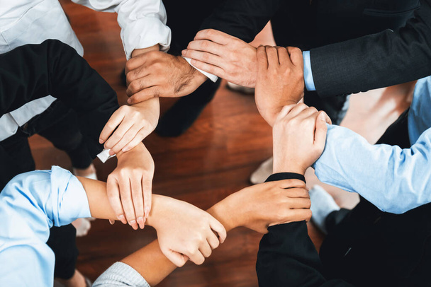 Multicultural business people holding hand together in circle. Unity teamwork in office business workplace. Diverse ethnic office worker engaged in team building. Meticulous - Photo, Image