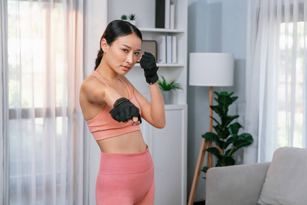 Ajuste joven mujer asiática retrato en ropa deportiva preparándose antes de la rutina de ejercicio saludable en casa. Entrenamiento de fitness doméstico en la sala de estar. Vigoroso - Foto, Imagen