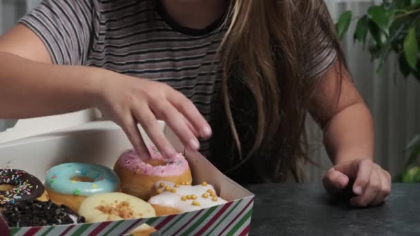 una chica con una caja de rosquillas deliciosas dulces - Imágenes, Vídeo