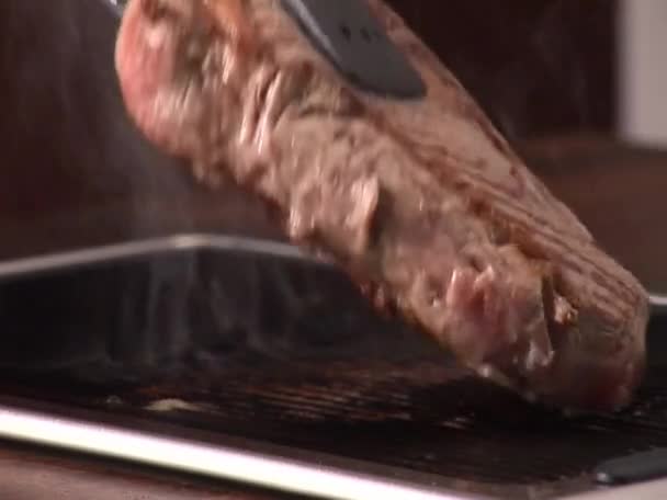Turning beef steak on grill - Footage, Video