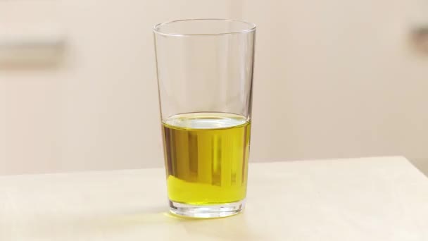Glass of olive oil being taken - Кадры, видео