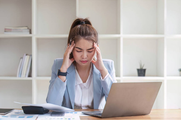 Mujer asiática confusa pensando en cómo resolver problemas en línea mirando a la pantalla del ordenador portátil. seria asiática mujer de negocios preocupado centrado en la resolución de difícil equipo en la oficina. - Foto, Imagen