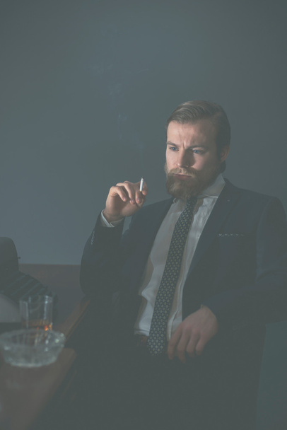 Вінтажний бізнесмен сидить палити
 - Фото, зображення