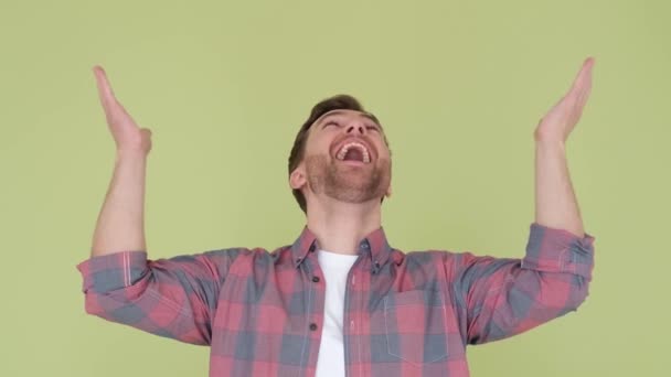 Half lichaam portret van lachende opgewonden man in t-shirt met open hand gebaar op studio achtergrond. - Video