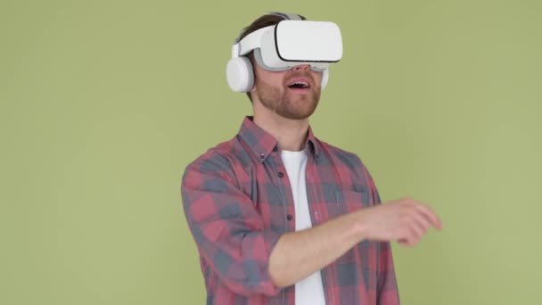 Bell'uomo che indossa occhiali di realtà virtuale su sfondo isolato capovolgendo schermo con le mani per presentare il prodotto. Tecnologie virtuali - Filmati, video