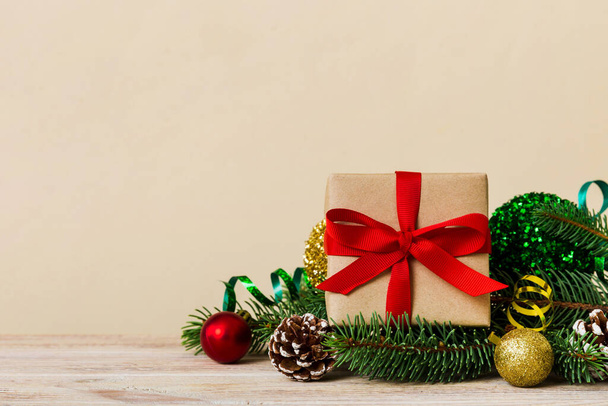 Новорічний різдвяний настрій, подарункова коробка, гілки христми, новорічні прикраси на кольоровому тлі.. - Фото, зображення