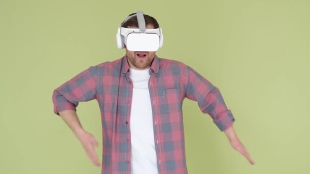Uomo divertente danza utilizzando vetro realtà virtuale su sfondo in studio. Utilizzando gadget moderni per l'intrattenimento. - Filmati, video
