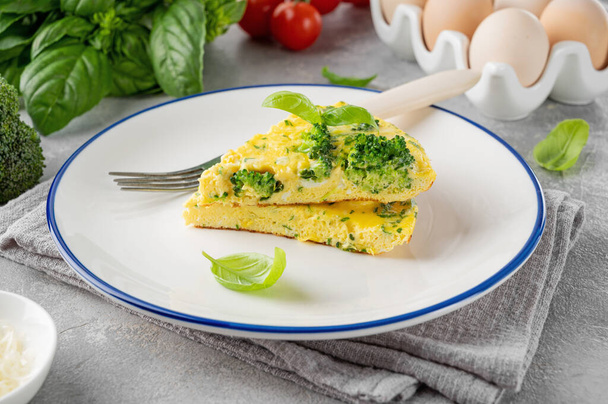 Brokolili omlet, peynir ve gri beton arka planda taze fesleğen. Sağlıklı kahvaltı. - Fotoğraf, Görsel
