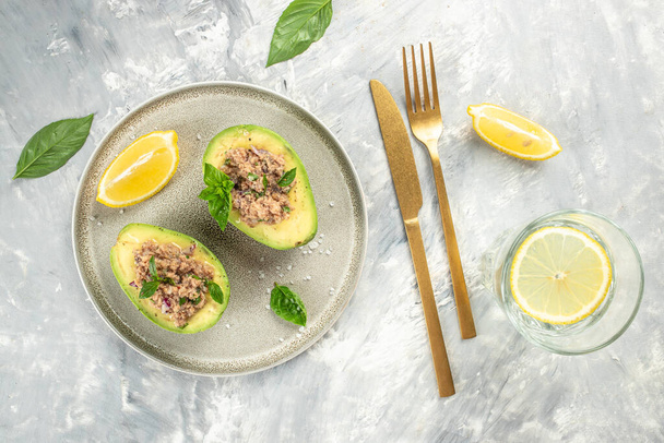 Avocado stuffed with tuna. Ketogenic diet. Low carb high fat breakfast. Healthy food concept. place for text, top view. - Photo, Image