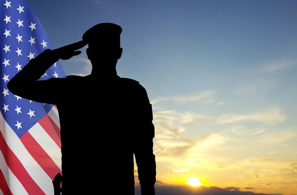 Silhouette di un soldato con bandiera USA contro il tramonto. Biglietto di auguri per la Giornata dei Veterani, Giorno della Memoria, Giorno dell'Indipendenza - Foto, immagini