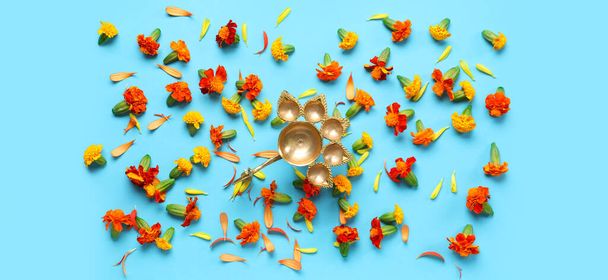 Масляна лампа з квітами чорнобривців на світло-блакитному тлі. святкування Divaly - Фото, зображення