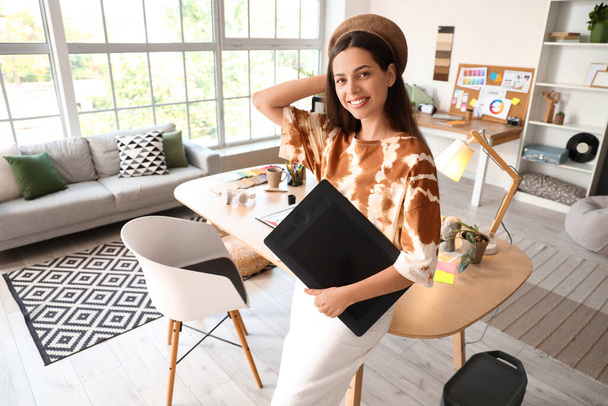Vrouwelijke interieurontwerper met grafische tablet op kantoor - Foto, afbeelding