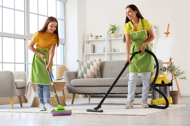 Onnellinen äiti pienen tyttärensä kanssa siivoamassa kotona - Valokuva, kuva