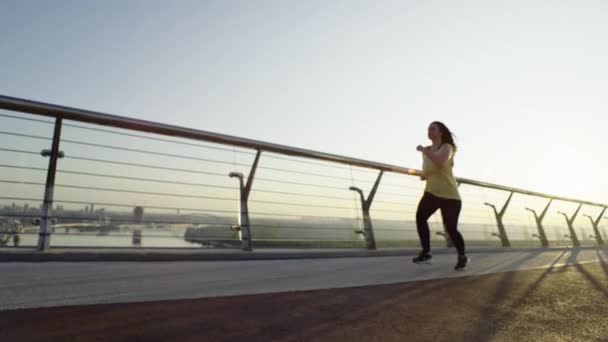 An overweight girl on a morning run in an urban cityscape. A girl loses weight by running, an idea. Active sports and fitness are a way of life. High quality 4k footage - Footage, Video