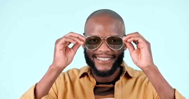 Sunglasses, happy and face of black man in a studio with stylish, cool and trendy fashion. Smile, style and confident young African male model with edgy face accessory isolated by white background - Footage, Video