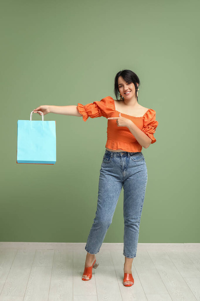 Kaunis onnellinen nainen ostoskassit vihreällä taustalla - Valokuva, kuva