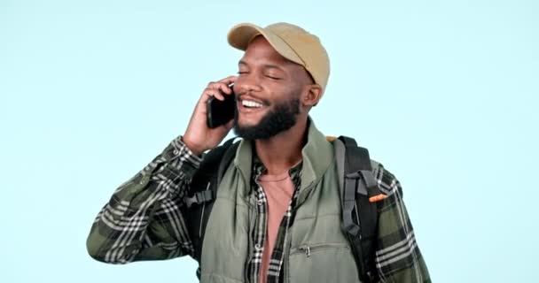 Hiking, phone call or black man with a smile, conversation or connection on a blue studio background. African person, model or hiker with a smartphone, mobile user or digital application with network. - Footage, Video