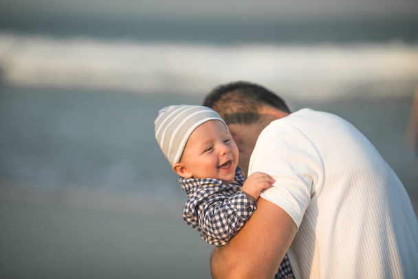 Szczęśliwego Dnia Ojca. Ojciec i dziecko bawią się na plaży. Tata i on Dziecko razem cieszą się zachodem słońca. Kochający samotny ojciec przytula słodkiego synka. - Zdjęcie, obraz