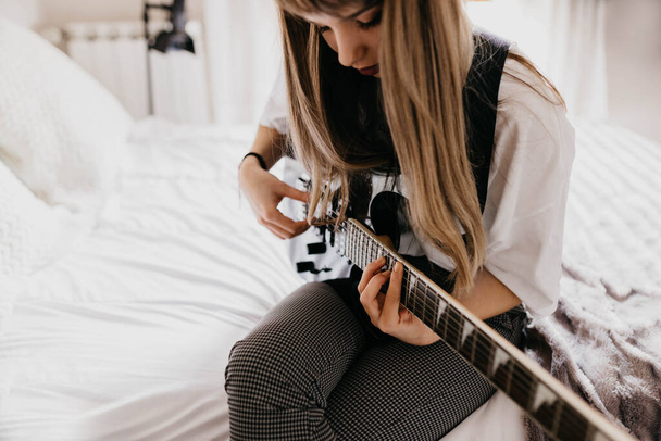 молодая брюнетка играет на гитаре - Фото, изображение