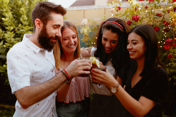 Grupo de amigos alegres tintineando vasos en la fiesta - Foto, Imagen