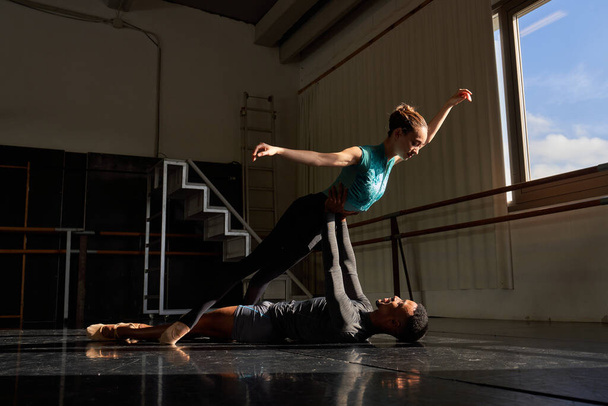 Paar aus schwarzem Jungen und weißem Mädchen in einer Klasse, die eine Ausbildung in der Ballettakademie macht - Foto, Bild