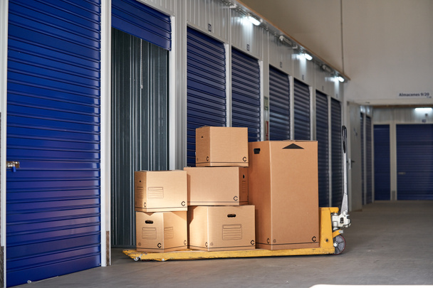 Lagerung in einem Industriegebäude zur Vermietung an Unternehmer oder Einzelpersonen mit recycelbaren Kartons auf einem Palettenregal - Foto, Bild